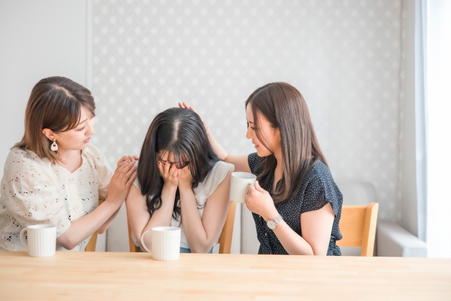 落ち込む女性と慰める友だち